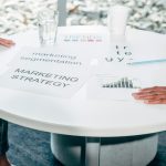 Dois profissionais colaborando em plano de negocios e estrategia de marketing em mesa