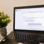 Laptop com interface de e-mail aberto em mesa de trabalho, representando automação de marketing para pequenas empresas.