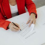 Empresaria assinando documento oficial para abertura e formalizacao de empresa