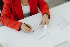 Empresaria assinando documento oficial para abertura e formalizacao de empresa